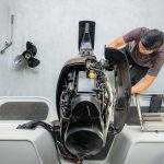 Repairing engines on aluminum boats , The technician is removing the boat parts to make the paint